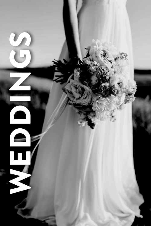 A grey tinted image of a woman in a wedding dress, holding a bouquet. The image represents the Weddings lifestyle range of corporate gifts and promotional products.