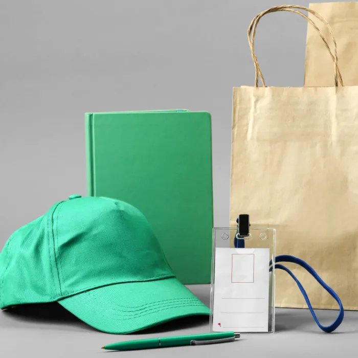 Green cap, notebook, pen, paper bag, and card holder displayed together, illustrating golf day ideas for branded giveaways.